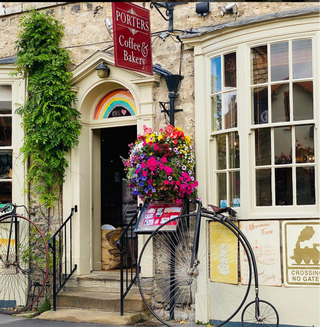 Vintage bicycle in front of a building with a sign for 'Porters Coffee & Bakery'.